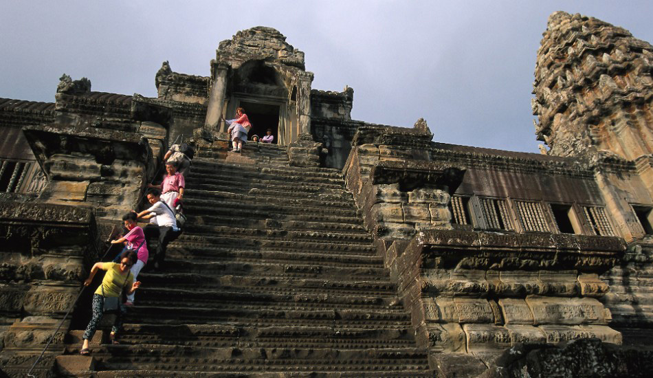 Храмы Ангкор-Ват, Камбоджа
Храмовый комплекс Ангкор-Ват в Камбодже— знаковое место для буддистов со всего мира. Нет ничего постыдного в том, чтобы карабкаться по ведущим к самому верхнему храму ступенькам на четвереньках или с помощью специальных веревок, ведь уклон у лестницы — примерно 70 градусов. Местные гиды объясняют, что лестница была сделана столь крутой, чтобы напомнить людям, что попасть на небеса — занятие не самое простое. Впрочем, находясь наверху, то же самое вы можете подумать и о спускании с небес.