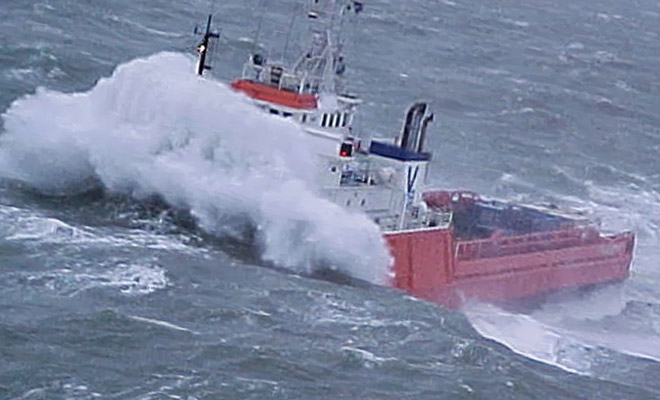 Корабль переваливает через цунами в открытом море
