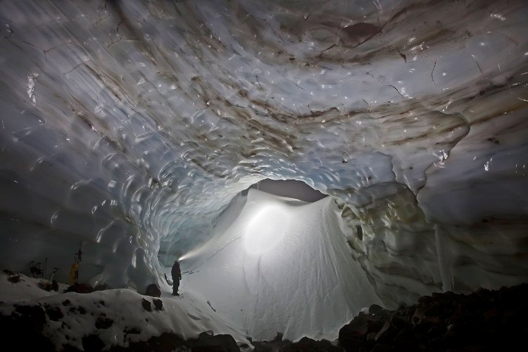 Первая экспедиция
Это фото сделано в январе 2012 года, когда Макгрегор и Картайа провели первое широкомасштабное исследование пещеры Снежный дракон. Вход шириной около 600 метров в ту пору запечатал зимний снег, создав стену высотой 9 метров. Если бы исследователи пришли хотя бы на неделю позже, вполне возможно, что вход был перекрыт полностью. Темные полосы во льду немного напоминают годовые кольца на деревьях, но на самом деле это вмерзавшие столетиями в лед горные породы.