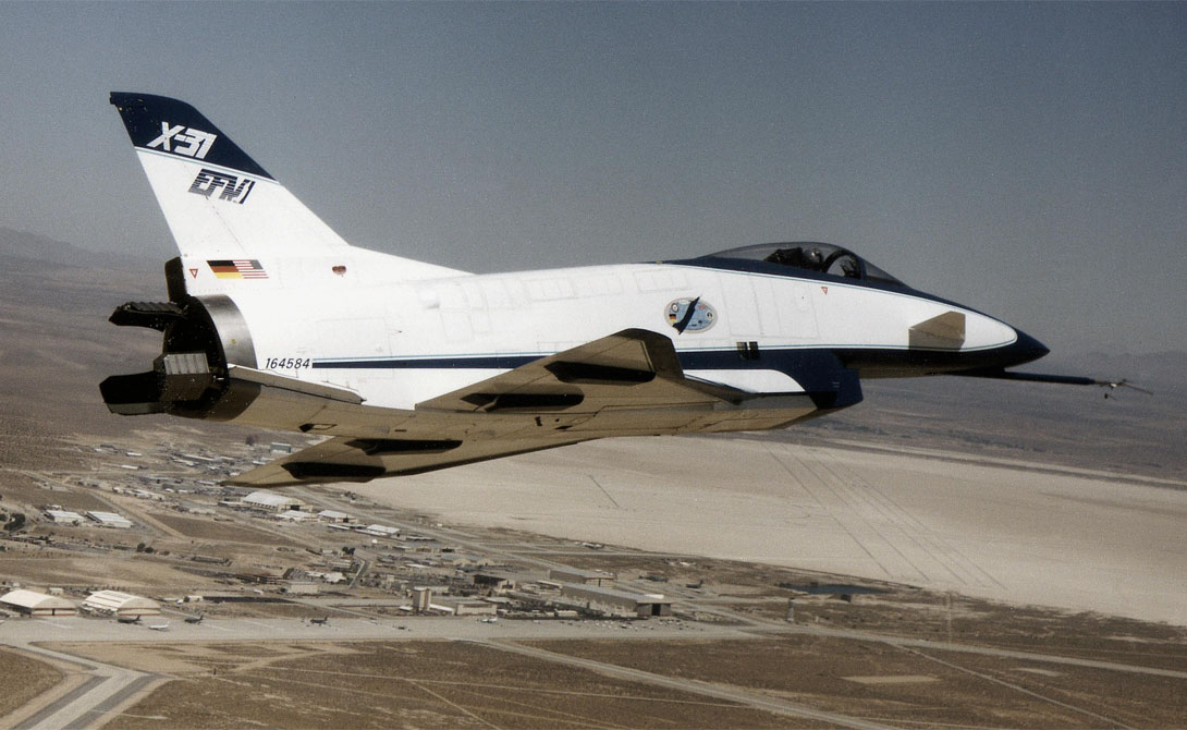 X-31A
Потом был X-31A, суперподвижный военный корабль, который мог повернуть на 180 градусов прямо в воздухе. Там, где другие самолеты выходили из-под контроля, этот красавец показывал чудеса акробатики, способные впечатлить даже птицу. X-31A получил звание самого быстрого самолета земли — на собственной реактивной струе он достигал скорости в девять раз большей скорости звука.