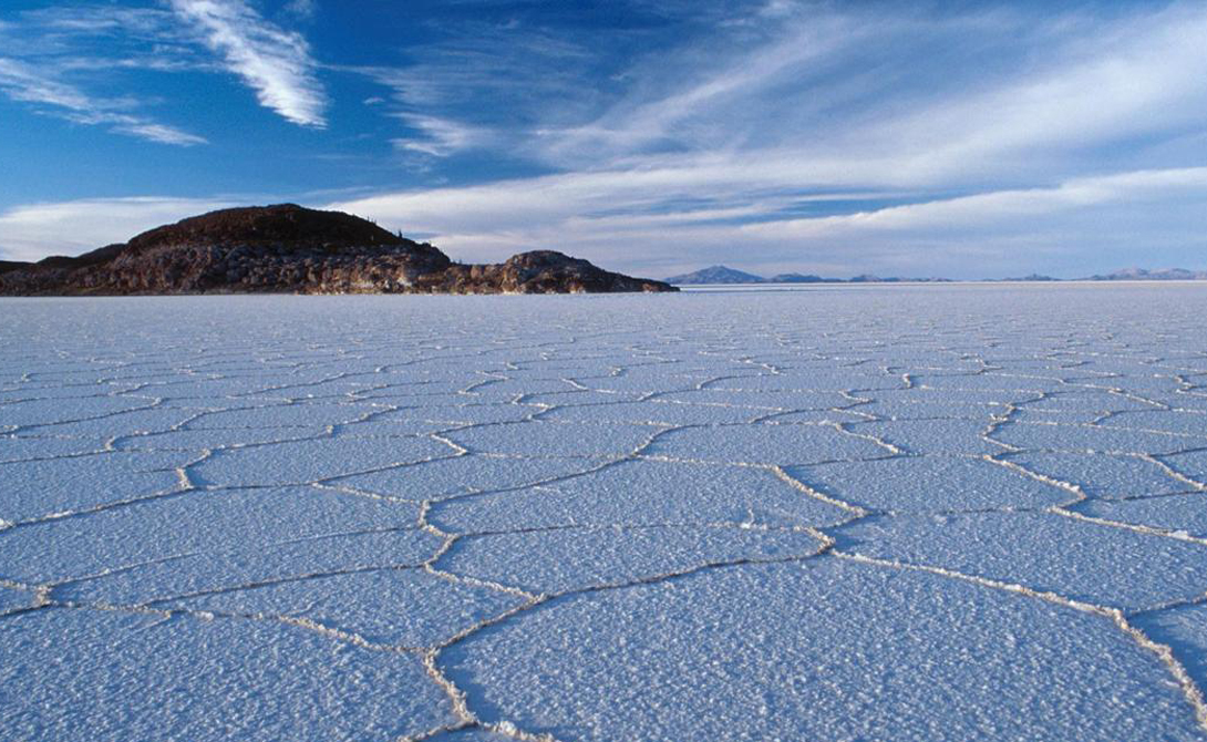 Салар-де-Уюни
Боливия
Самый большой в мире запас соли находится в Боливии. Салар де Уюни занимает площадь в 10500 квадратных километров. Это все, что осталось от доисторического мегаозера. Бассейн вымощен раздутыми гексагональными кристаллами соли, простирающимися до самого горизонта. Под незыблемой корой собирается рассол, богатый минералами. Помимо всего прочего, он содержит половину мирового запаса лития.