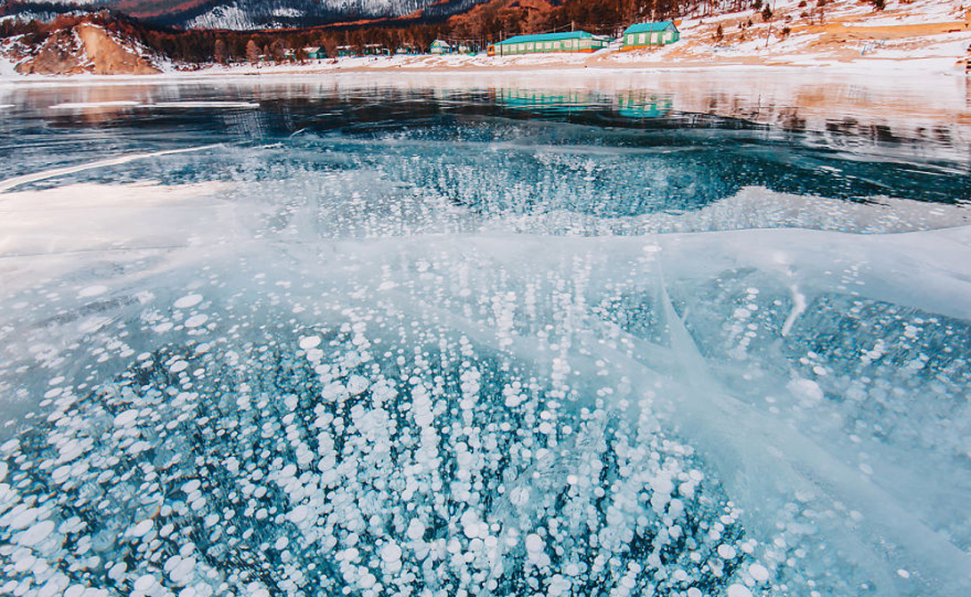 Жемчужины
И видите эти пузырьки? Будто стеклянные шарики, замерзшие во времени — на самом деле, это вырабатываемый водорослями метан. Маленькие, похожие на жемчуг шарики стали одной из причин, по которым озеро прозвали «Жемчужина Сибири».
